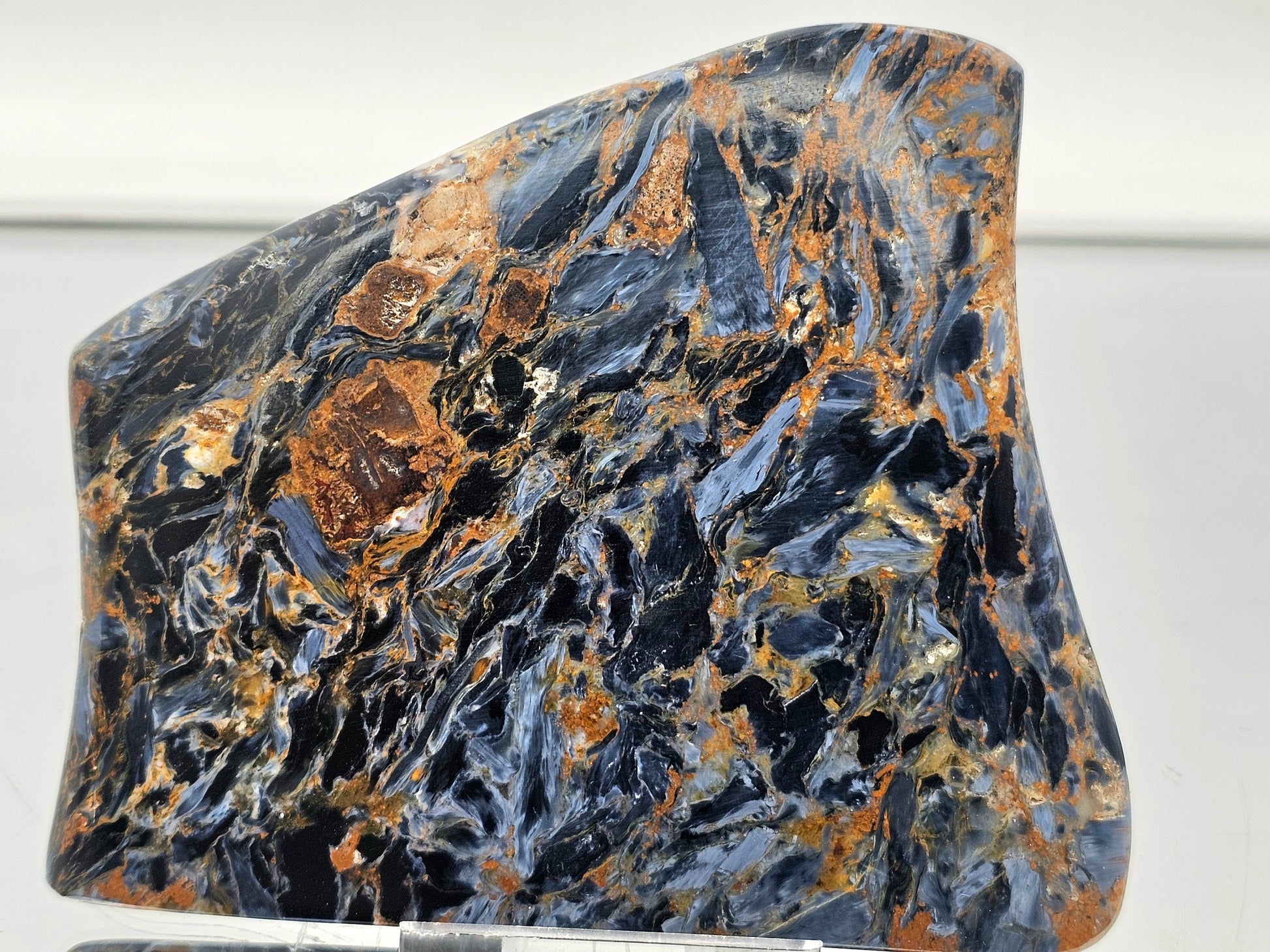 Close-up of polished pietersite slice showcasing vibrant color variations