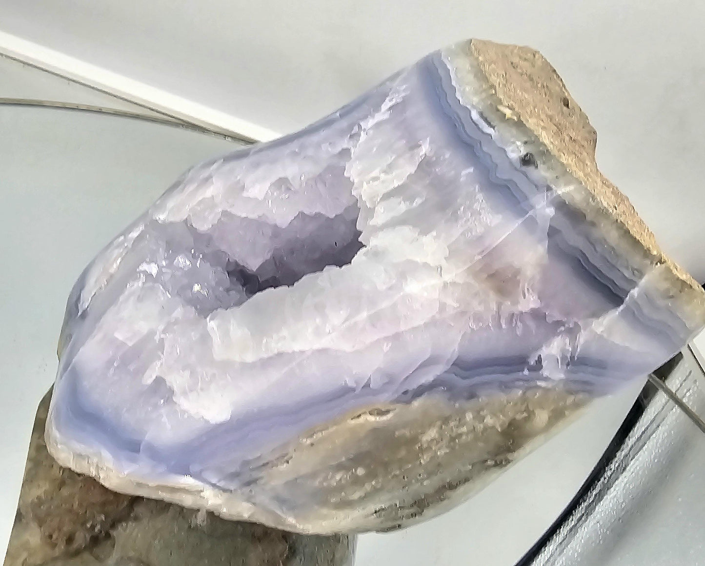 Blue agate geode crystal with polished interior and raw edge