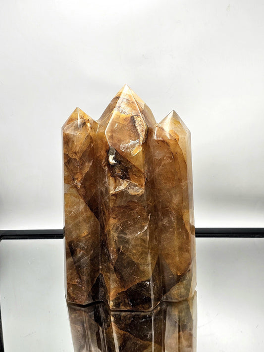 Very large Golden Healer Hematoid Crystal Triple Prism, hand-carved from Madagascar, ideal for luxurious interiors.