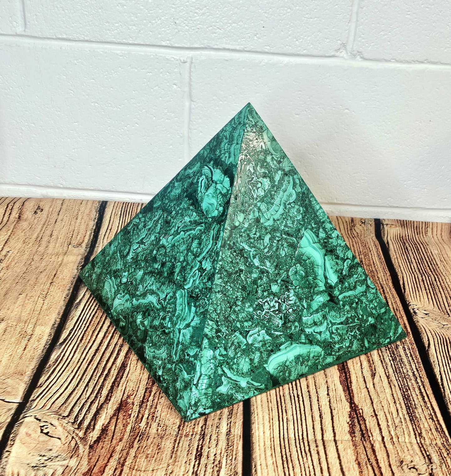 Vibrant malachite pyramid in green tones, perfect for interior styling.