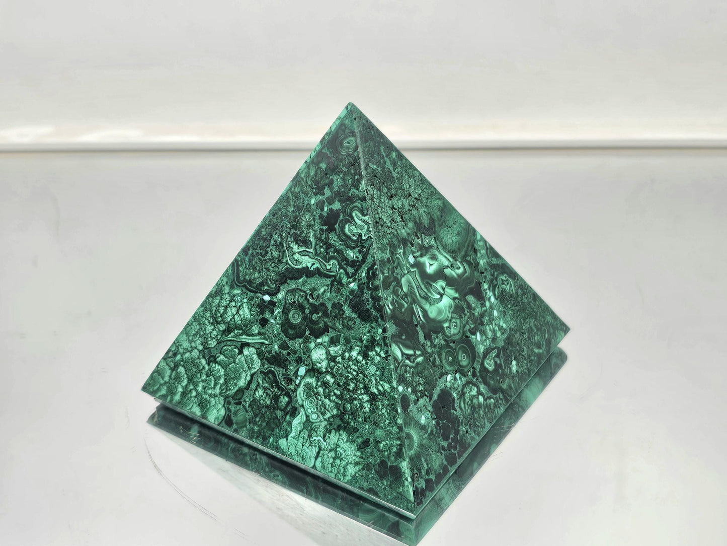 small malachite pyramid with rich green bands, perfect for luxury interior design.