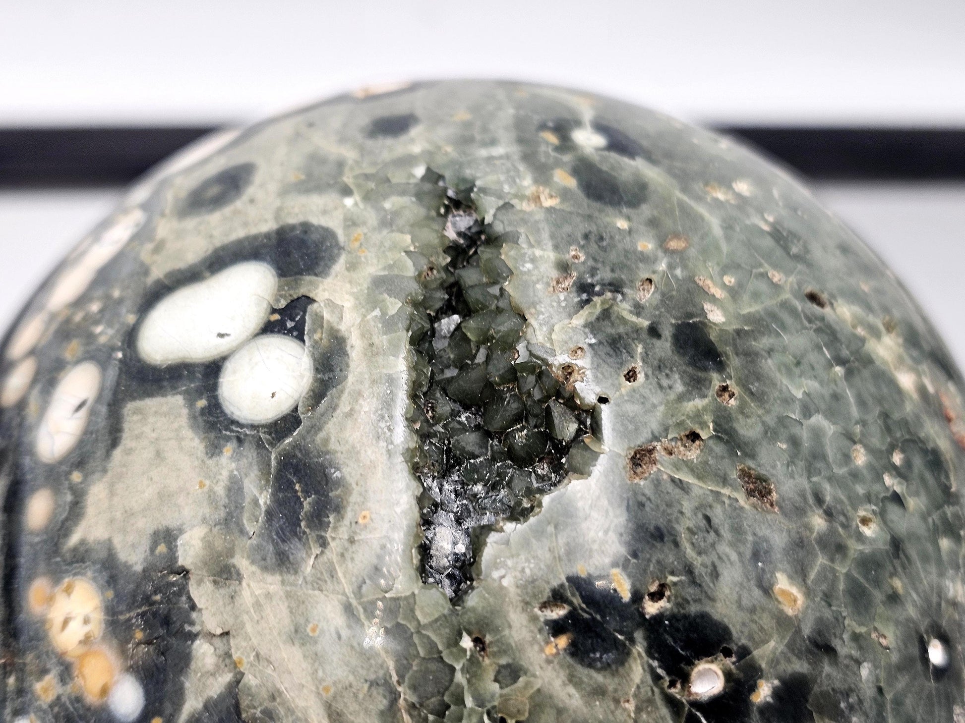 Stunning Ocean Jasper sphere with natural cavities and polished finish.
