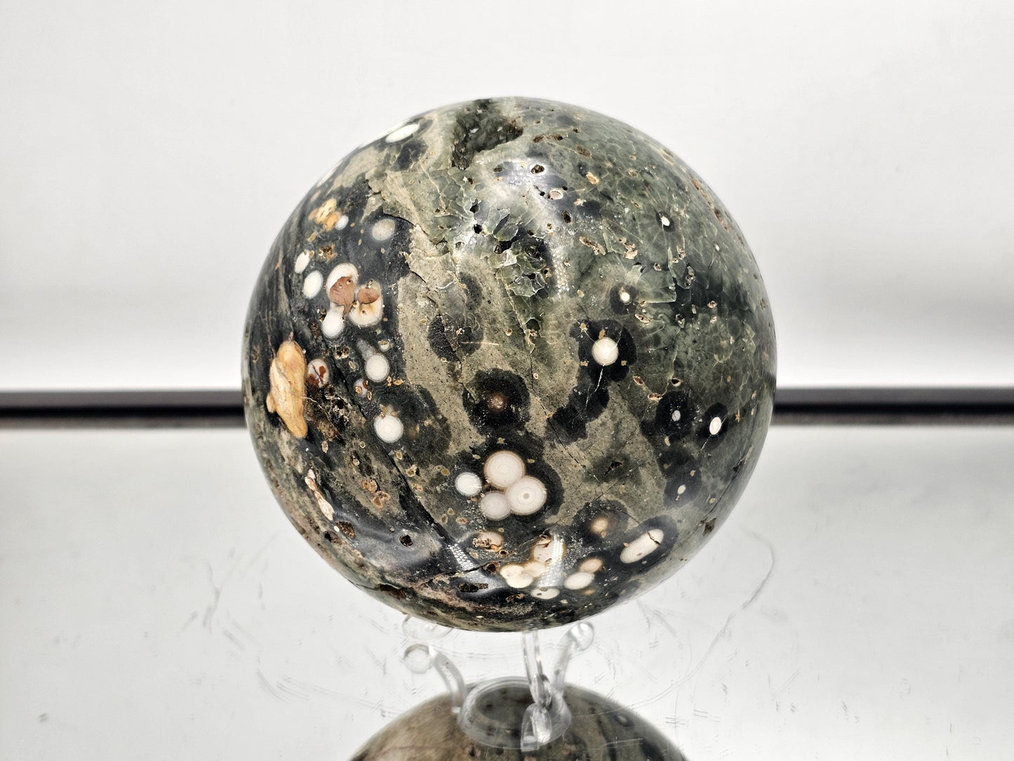 Handcrafted orbital Ocean Jasper sphere with intricate natural cavities.