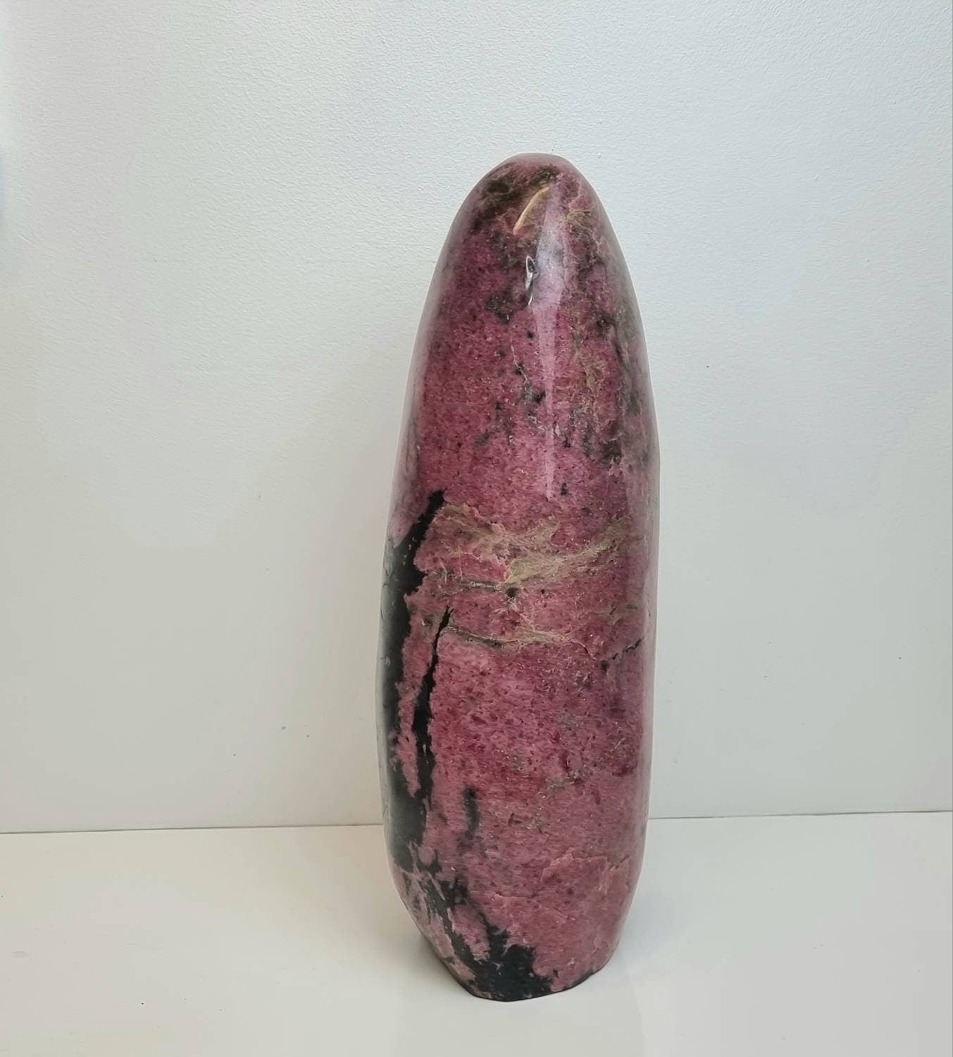 Side view of very large rhodonite crystal freeform.  Unique decor black and pink